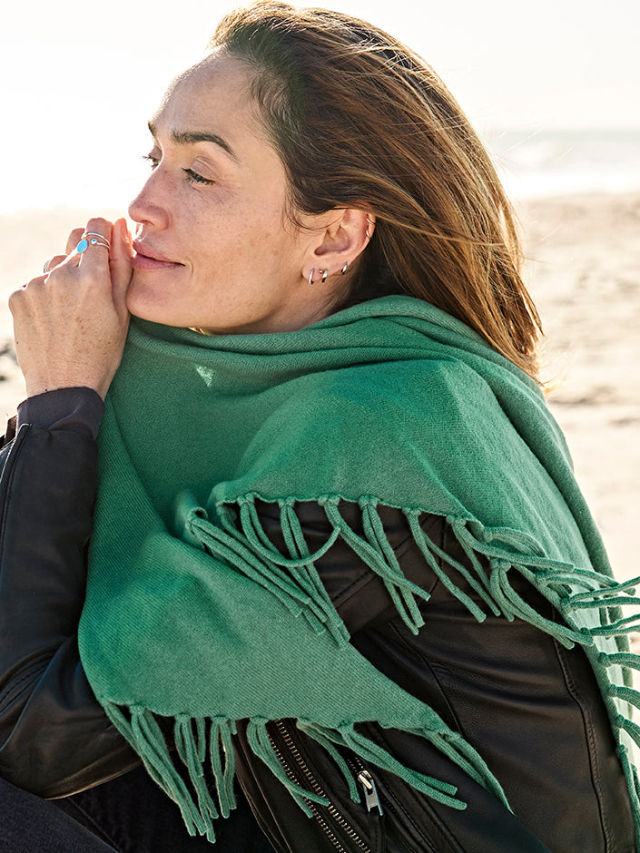 Model trägt grünen EMAAL CASHMERE LOS ANGELES Dreiecksschal in eleganter Outdoor-Szene#Farbe_grün