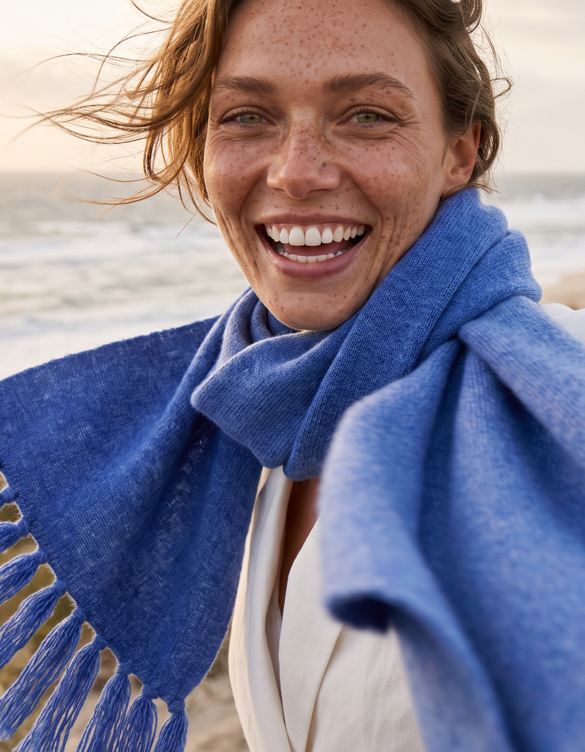 Portrait einer Frau am Strand mit Milano Schal#Farbe_Jeansblau