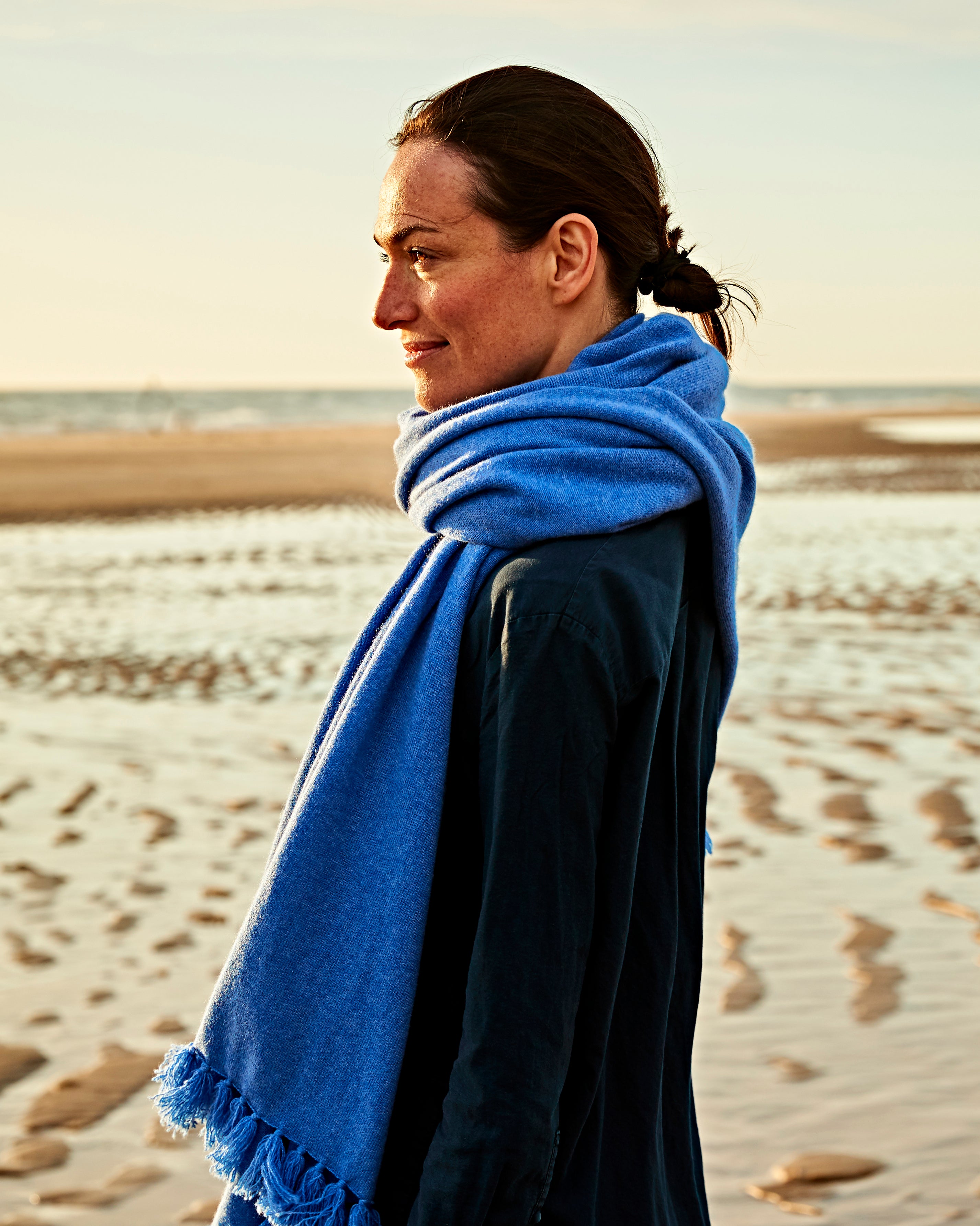 Frau schaut in die Ferne mit EMAAL CASHMERE Schal um#Farbe_Jeansblau