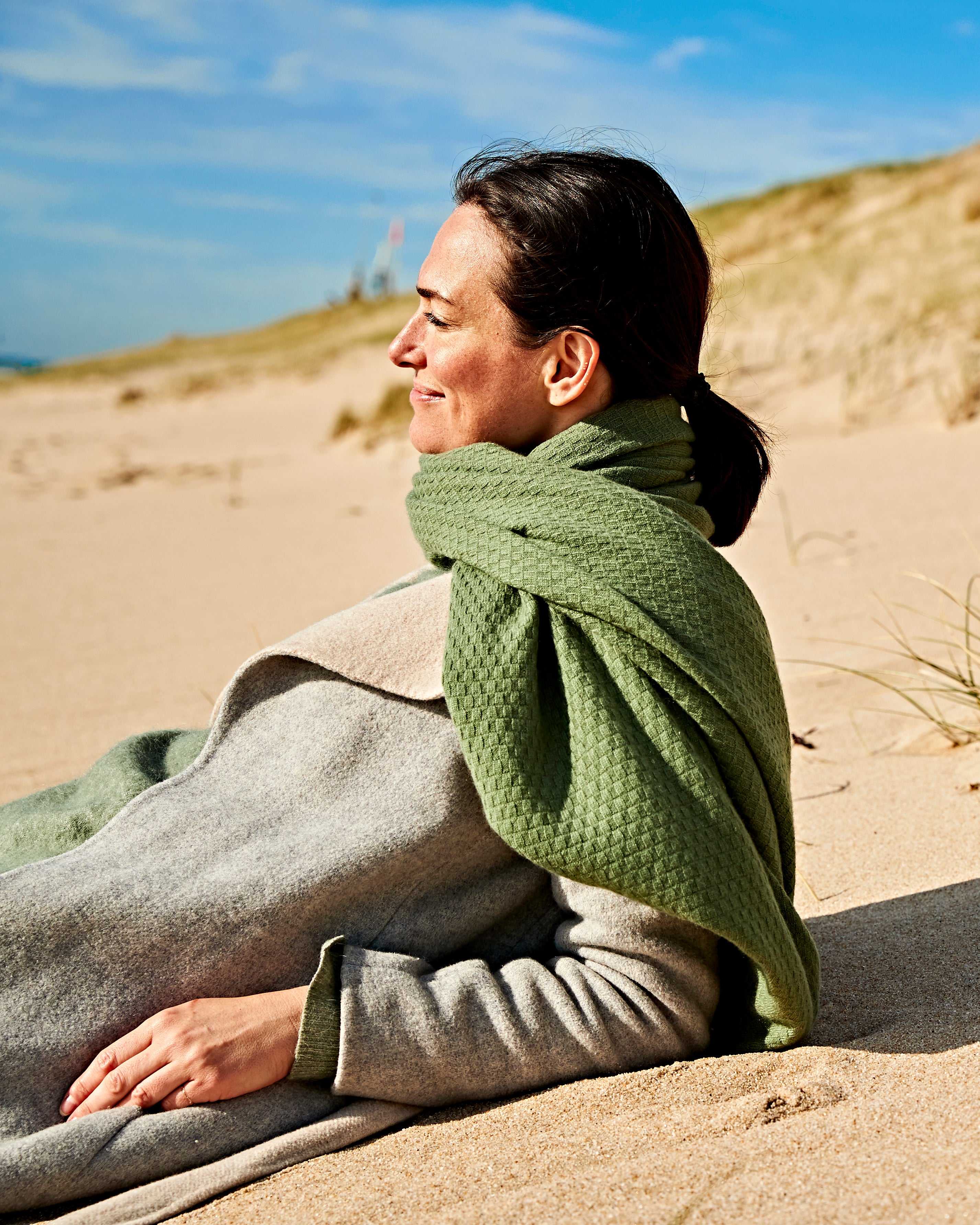 Frau am Strand von Sylt mit Kaschmir EMAAL Schal#Farbe_Olivengrün